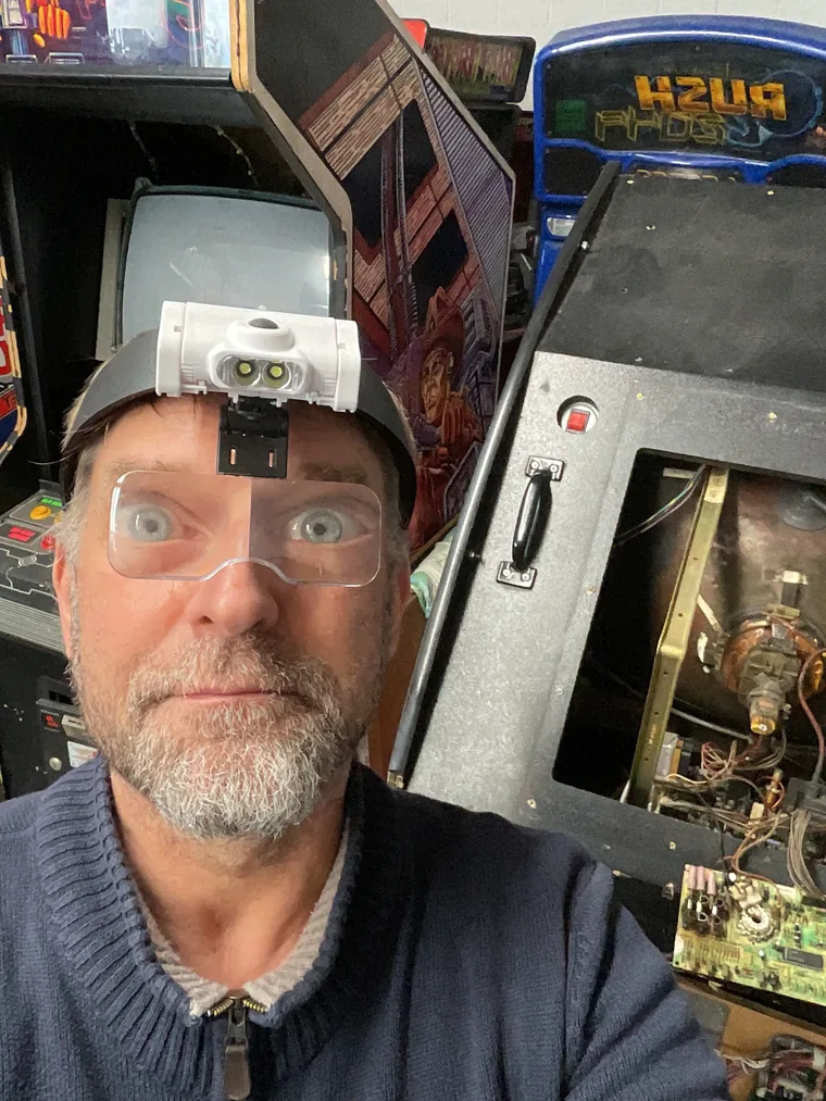 René mit Kopflupe bei der Reparatur an einem geöffneten Automaten